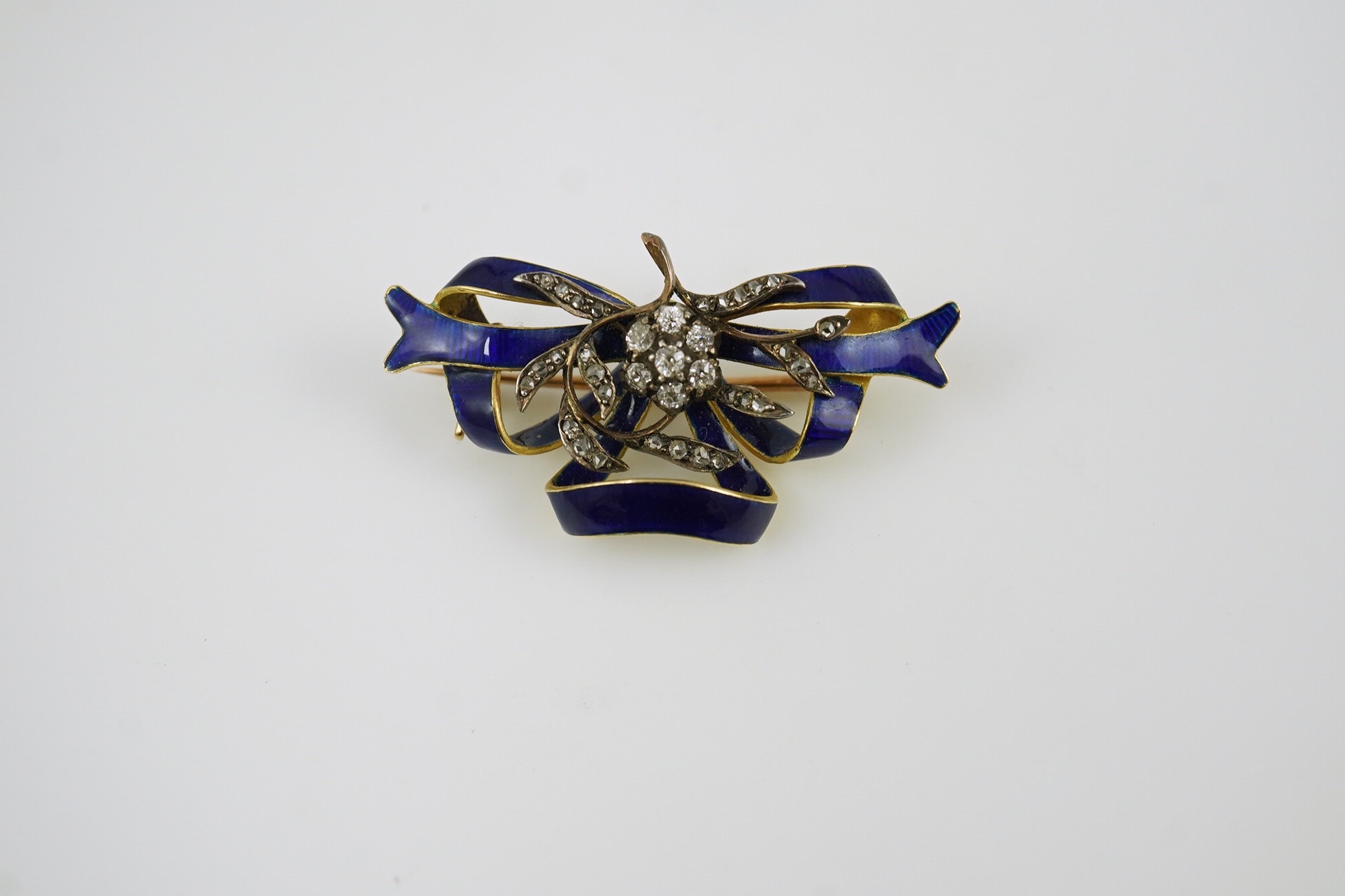 A Victorian gold, diamond cluster and blue enamel set ribbon bow brooch